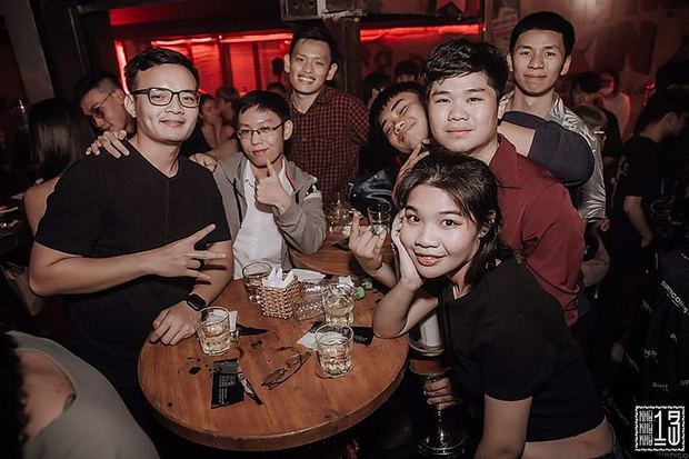 Một bàn bạn bè ngồi kín quanh nhau.
